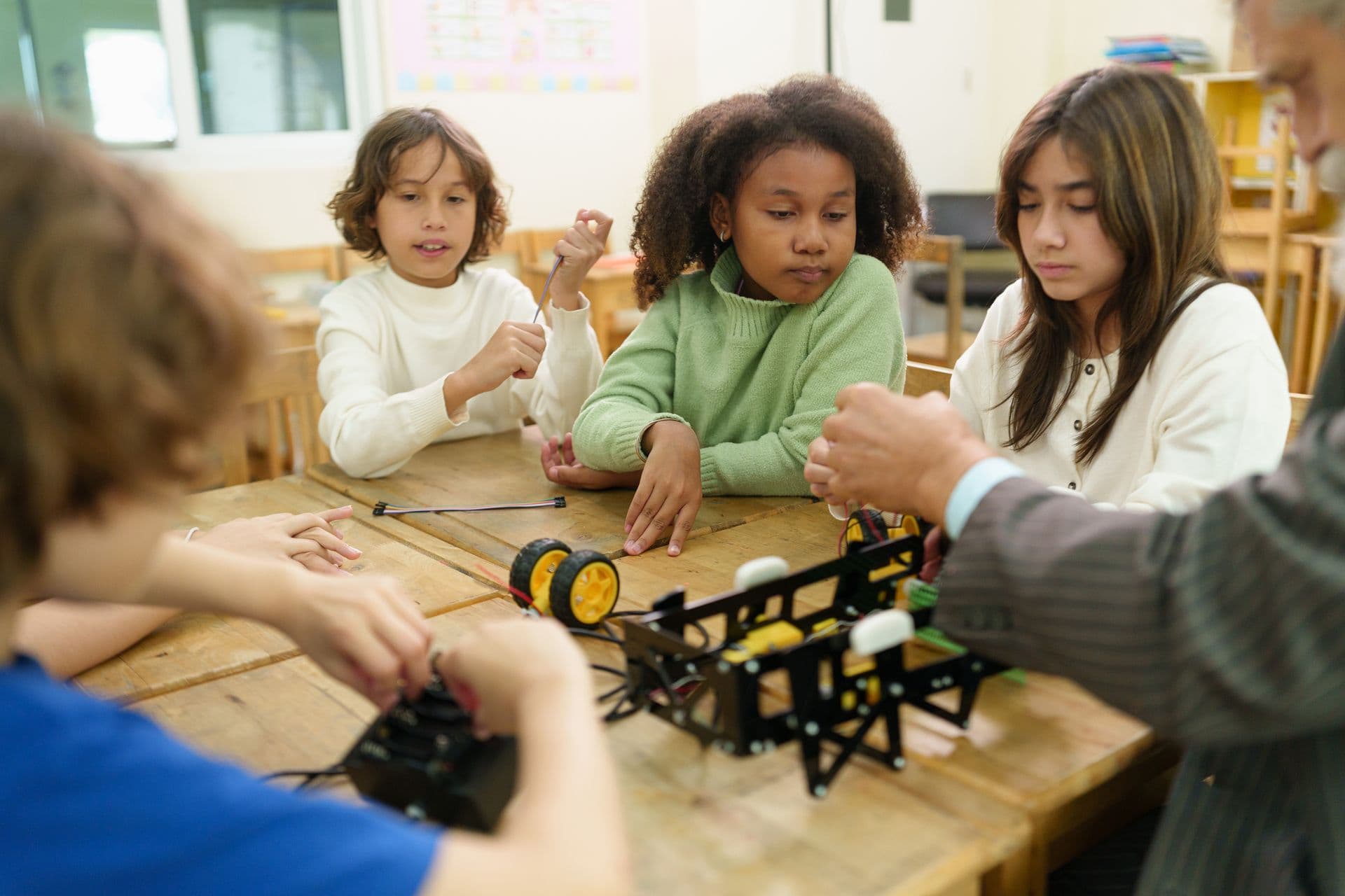 Children building a robot together at a table